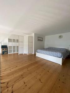 una camera da letto con un letto e un pavimento in legno di Appartamento IL GLICINE a piano terra zona tranquilla a due passi dal mare a Lido di Savio