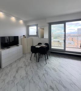パリにあるApartment My HOME Eiffel Tower Viewのテーブルと椅子とテレビのあるリビングルーム +20枚の写真