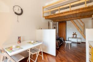 cocina y sala de estar con mesa y reloj en Ciprian, en Bolonia 17 fotos más