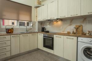 a kitchen with white cabinets and a washing machine at Filoxenia house in Kremasti