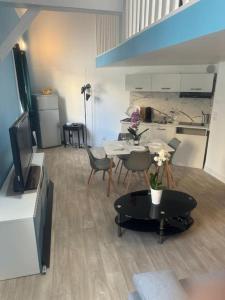 a living room with a table and a kitchen at Appartement cozy proche de toutes commodités in Gagny