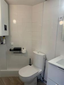 a white bathroom with a toilet and a sink at Appartement cozy proche de toutes commodités in Gagny