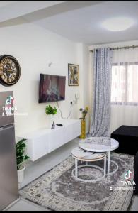 a white living room with a table and a couch at Luxore appartments in Nairobi