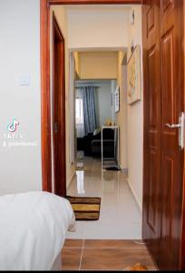 a room with a bed and a hallway with a living room at Luxore appartments in Nairobi