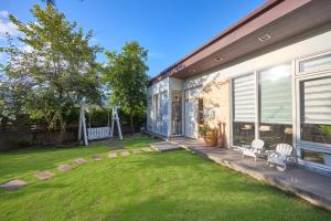 a house with a yard with two chairs on it at OwlStay Green Villa in Pinghe