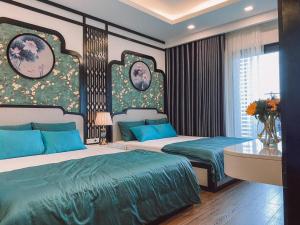 una camera con due letti con lenzuola blu e verdi di Căn Hộ Du Lịch 5 Sao FLC Sea Tower Quy Nhơn-Trung tâm Thành Phố Cách Biển 50m a Quy Nhon