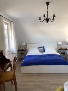 een slaapkamer met een groot bed met een blauwe deken bij Haffkoje - Ferienhaus mit Kamin und Sauna für 6 Personen in Pepelow