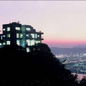 a large building on top of a hill at dusk at Hotel Bokaiso in Takamatsu