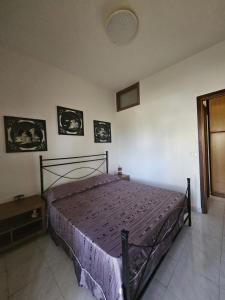 a bedroom with a bed with a purple bedspread at Don Vladi in Letojanni