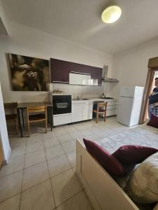 a kitchen with a couch and a table in a room at Don Vladi in Letojanni +18 photos