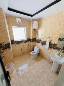 a bathroom with a toilet and a sink at Hilton Resort Malamjabba by Khan Familia Travels in Malam Jabba