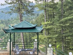 a gazebo with two chairs on a deck with trees at Hilton Resort Malamjabba by Khan Familia Travels in Malam Jabba +14 photos