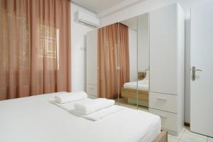 a bedroom with a white bed and a mirror at Mythodea Home Apartments in Limenas