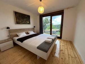 a bedroom with a large bed and a large window at Svetli Raj in Pregrada