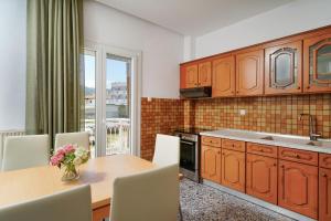 a kitchen with a table with a vase of flowers on it at Mythodea Home Apartments in Limenas