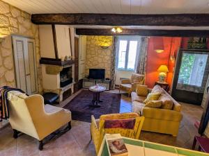 a living room with couches and chairs and a tv at Le Relais Laviolette in Cruis