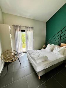 a bedroom with a large bed and a chair at Auberge de Planzolles in Planzolles