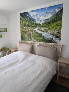 una camera da letto con un letto e un dipinto sul muro di Apartment Bergzeit Sterzing a Vipiteno
