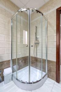 a shower with a glass door in a bathroom at Stunning view, Sliema Seafront, 2bedroom apt in Sliema