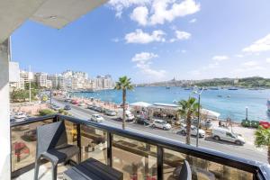 a balcony with a view of a city and the ocean at Stunning view, Sliema Seafront, 2bedroom apt in Sliema