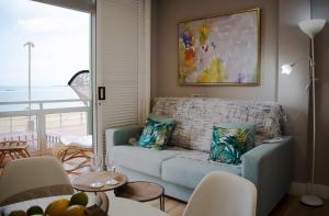 a living room with a blue couch and a window at TC Lindamar in Las Palmas de Gran Canaria