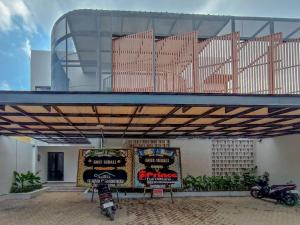 a building with signs and motorcycles parked under a roof at Urbanview Hotel Subali Purwokerto in Purwokerto +31 photos