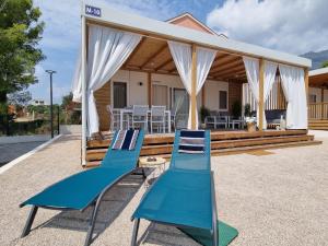 a house with two chairs and a gazebo at Mobile Home Blue Charm Camping Dalmata Orebić in Orebić