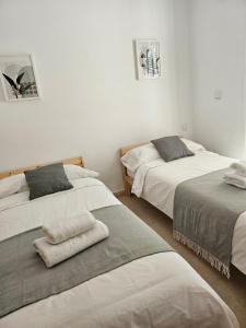a bedroom with two beds with towels on them at Chalet Benajarafe Beach Malaga in Benajarafe