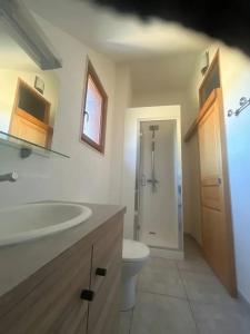 un bagno con un lavandino bianco e un water di Maison chaleureuse à Saint-Aventin avec jardin et vue montagne a Saint-Aventin Altre 6 foto
