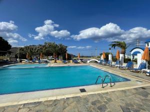 a pool with chairs and umbrellas at a resort at Happy Camp mobilehomes in Camping Apollonia in Plakias