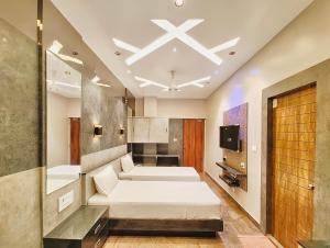 a room with two beds and a tv in it at M S RESIDENCY in Chennai