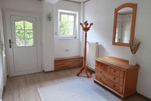 a room with a mirror and a dresser and a door at Ferienwohnung in idyllischer Lage in Wiesmoor