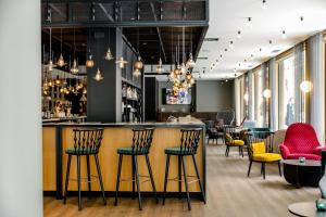 a bar in a restaurant with colorful chairs at Motel One Madrid-Plaza de España in Madrid