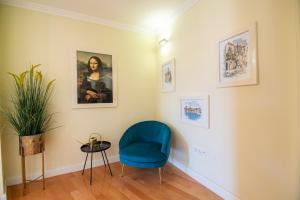 ein Zimmer mit einem blauen Stuhl und Bildern an der Wand in der Unterkunft Lucy Retreat - Split Center - Near Diocletian's Palace with Jacuzzi in Split + 49 Fotos