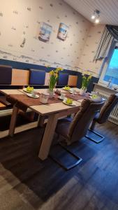 a dining room with a wooden table and chairs at Pension Sandra in Neuharlingersiel