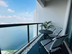 a balcony with a table and chairs and the ocean at R&F Seine Region at ANJU in Johor Bahru