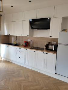 a kitchen with white cabinets and a white refrigerator at Urban Nest in Beauvais