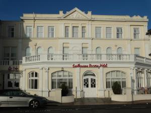 a white building with a white car parked in front of it at Eastbourne Riviera Hotel in Eastbourne