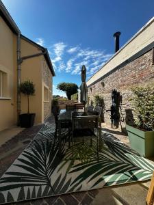 eine Terrasse mit Tisch und Sonnenschirm in der Unterkunft Le Biardais - Gîtes du Bessin in Balleroy