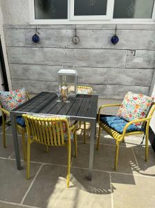 a black table with two chairs and a lantern on it at North View cottage. Shaldon village. in Shaldon