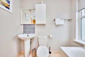 ein weißes Badezimmer mit Toilette und Waschbecken in der Unterkunft Princess Green 5 - Portrush by the Sea in Portrush + 34 Fotos