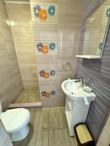 une salle de bain avec toilettes et lavabo dans l'établissement Vila Maria, à Eforie Nord