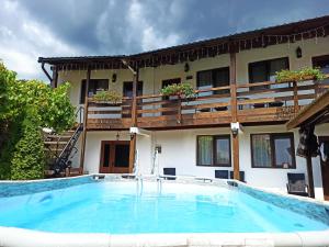 a large swimming pool in front of a building at Casa Rodica in Dubova +26 photos