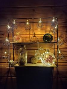 a shelf with glass jars and lights on it at Roulotte de la Ferme Les Chenevières in Villers-devant-Mouzon +13 photos