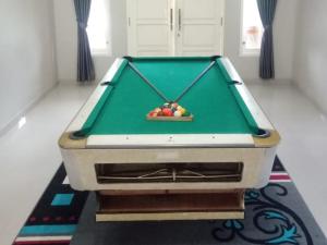 a pool table with a bowl of fruit on it at Villa Dalfa Puncak in Kopo 2 +8 photos