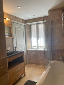 un bagno con doccia, lavandino e vasca di Chalet Muguet - Centre of Village location! a Les Allues Altre 43 foto