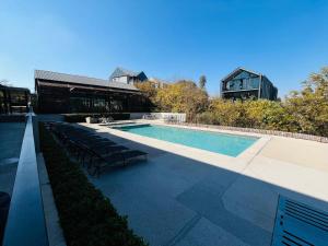 una piscina con sedie accanto a un edificio di 8 Elizabeth place - Beautiful self catering 1 Bedroom Apartment next to Kyalami Racetrack in Midrand with Free Wifi Local swimming pool Gym and Restaurant - perfect for a couple a Midrand