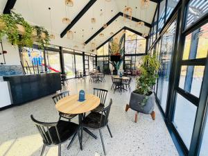 un tavolo e delle sedie in una stanza con finestre di 8 Elizabeth place - Beautiful self catering 1 Bedroom Apartment next to Kyalami Racetrack in Midrand with Free Wifi Local swimming pool Gym and Restaurant - perfect for a couple a Midrand