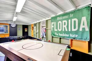 eine Tischtennisplatte in einem Raum mit einem Schild in der Unterkunft Fun Getaway: Hot Tub, Tiki Bar, Arcade Room in Hollywood + 110 Fotos