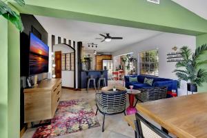 ein Wohnzimmer mit einem blauen Sofa und einem Fernseher in der Unterkunft Fun Getaway: Hot Tub, Tiki Bar, Arcade Room in Hollywood